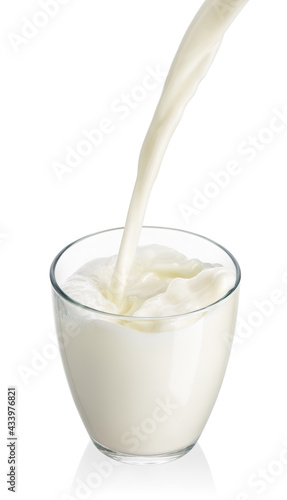 milk pouring into glass isolated on white