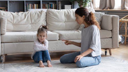 Bilde på lerret Strict young Caucasian mother talk lecture ill-behaved stubborn small preschooler daughter at home