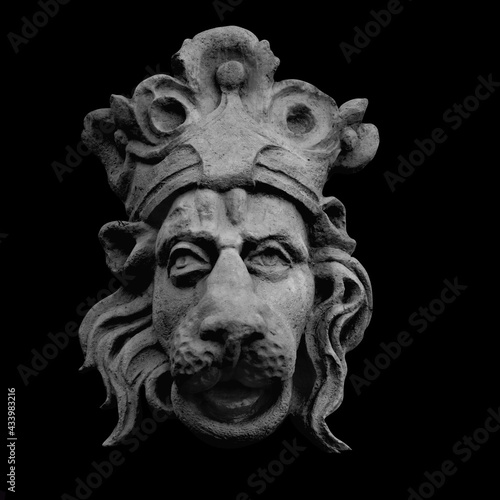 Lion King. An ancient statue isolated on black background.