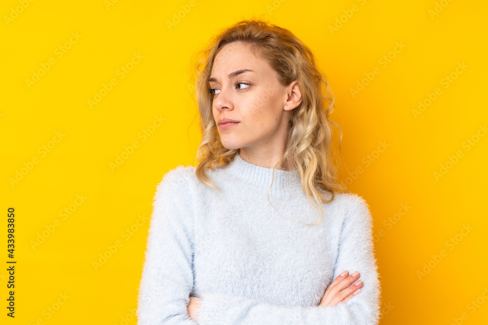 Fototapeta premium Young blonde woman isolated on yellow background portrait