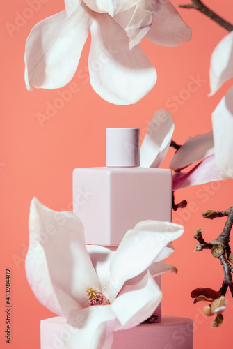 Cosmetic and magnolia branch on orange background