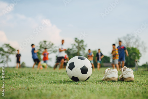Action sport outdoors of a group of kids having fun playing soccer football for exercise in community rural area