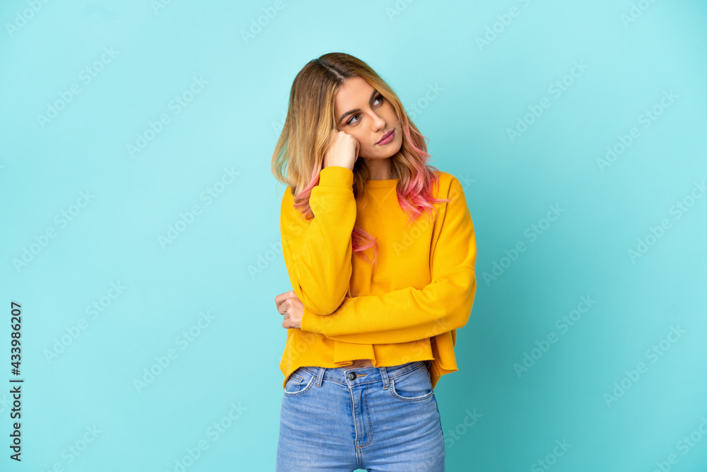 Young woman over isolated blue background with tired and bored expression Young woman over isolated blue background with tired and bored expression