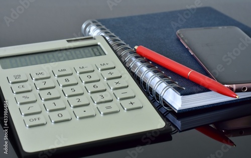 solar calculator, spring notebook, ballpoint pen and smartphone