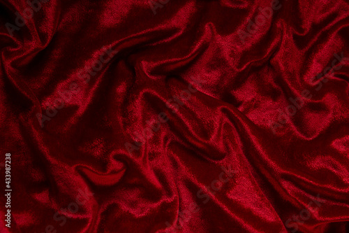 Dark red velvet textile background. Close up of fashion fabric. photo
