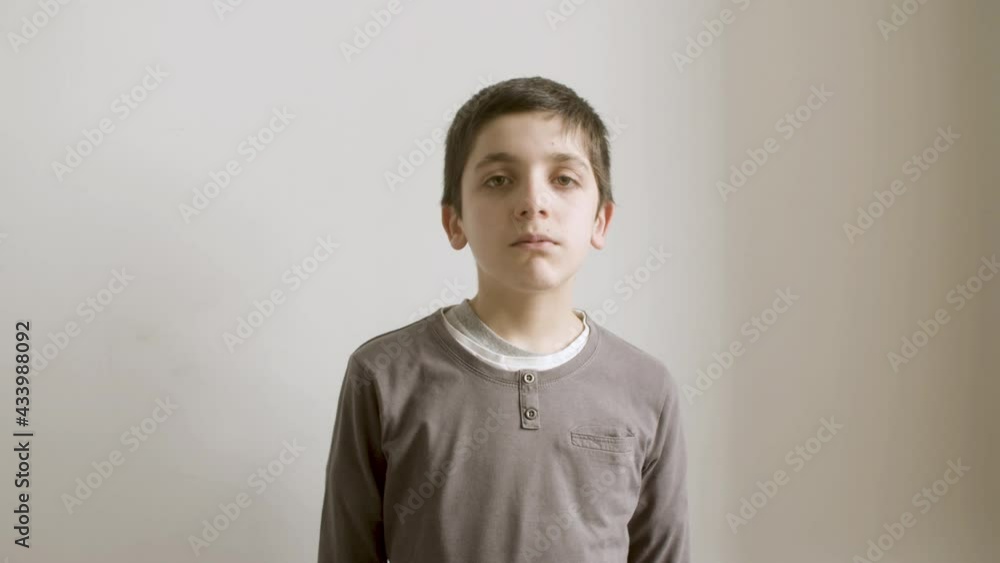 Young brunette boy looking and posing at camera. Kid isolated on white background, changing emotions on face from serious to happy. Schoolboy portrait concept. Young brunette boy looking and posing at camera. Kid isolated on white background, changing emotions on face from serious to happy. Schoolboy portrait concept.