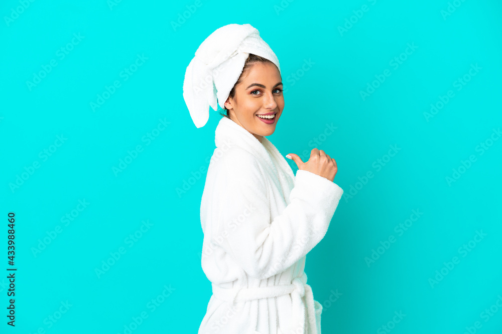 Young woman in a bathrobe over isolated blue background proud and self-satisfied Young woman in a bathrobe over isolated blue background proud and self-satisfied