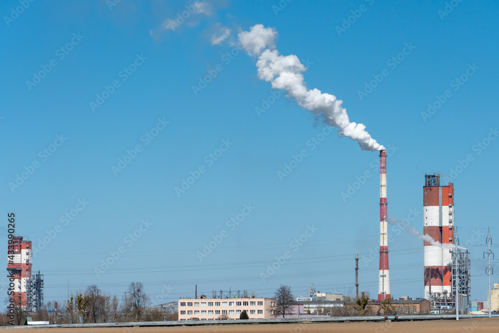 Thick white smoke coming out of a large pipe of an industrial facility or factory. A smoking chimney against a blue sky. Environmental pollution of chemical and pharmaceutical enterprises Thick white smoke coming out of a large pipe of an industrial facility or factory. A smoking chimney against a blue sky. Environmental pollution of chemical and pharmaceutical enterprises
