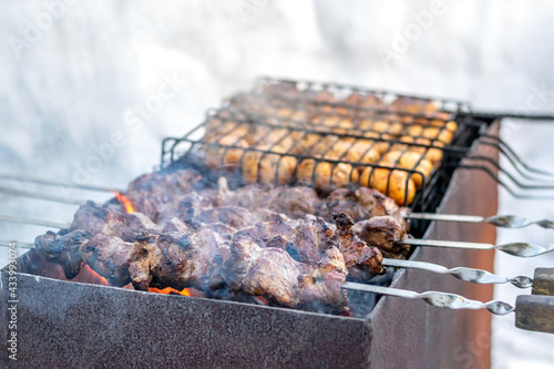 Pork on skewers and mushrooms on a grill grilled in winter.