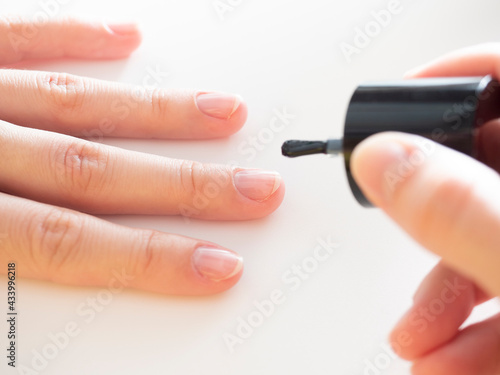 applying a colorless base to the nail. Manicure at home  nail care.