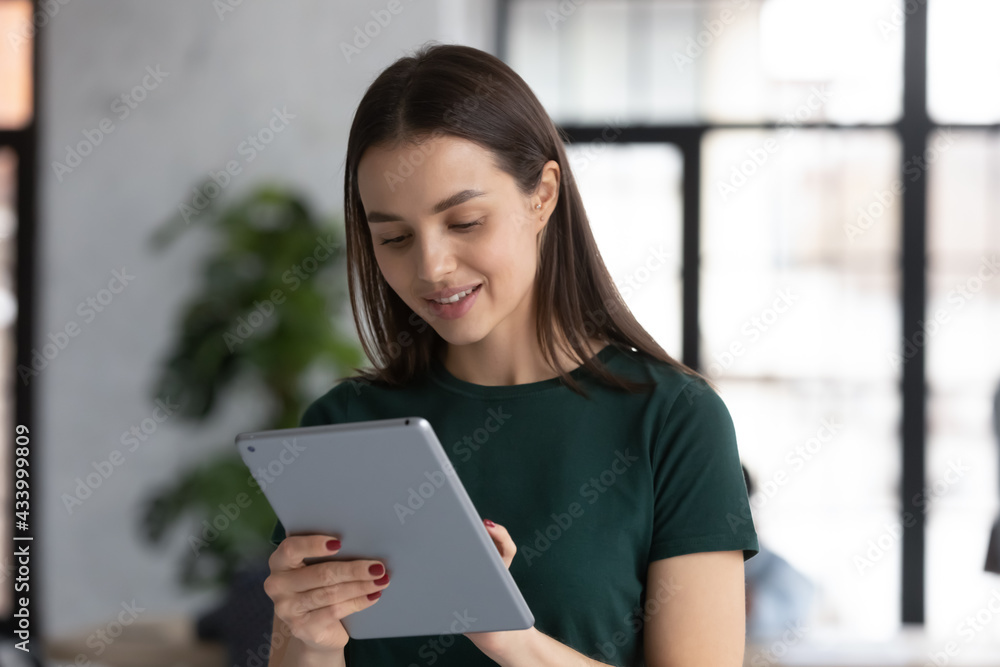 Fototapeta premium Happy student girl using educational app on tablet pc. Intern studying professional software in office. Manager chatting with client online. Support assistant giving internet consultation to customer