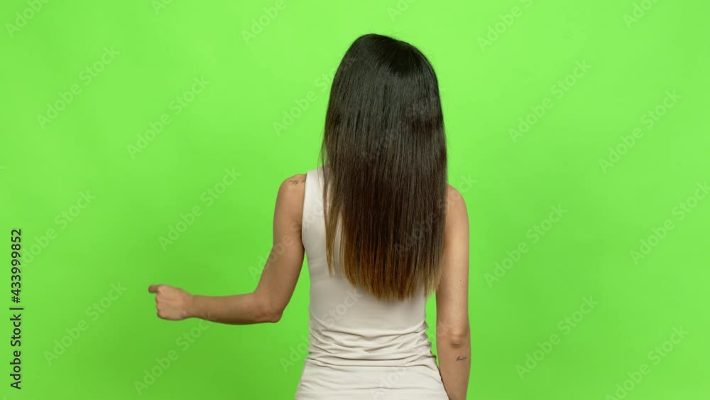 Young woman pointing back with the index finger over isolated background Young woman pointing back with the index finger over isolated background