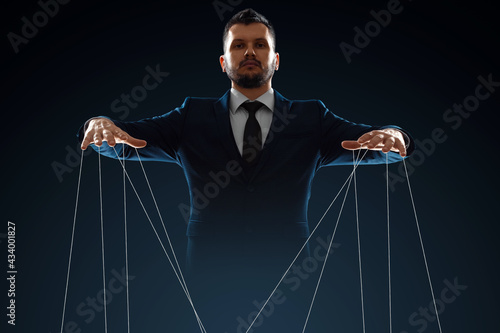 Male, puppeteer controls with threads. The concept of world conspiracy, world government, manipulation, world control. photo