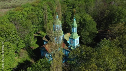 Aerial View of wooden church surrounded by high old trees. Pereyaslav-Khmelnitsky Museum of Folk Architecture and Life of the Middle Naddnipryanshchyna. photo