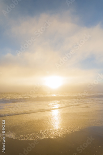 Golden sunset over ocean as a thick marine layer of is moving in towards shore