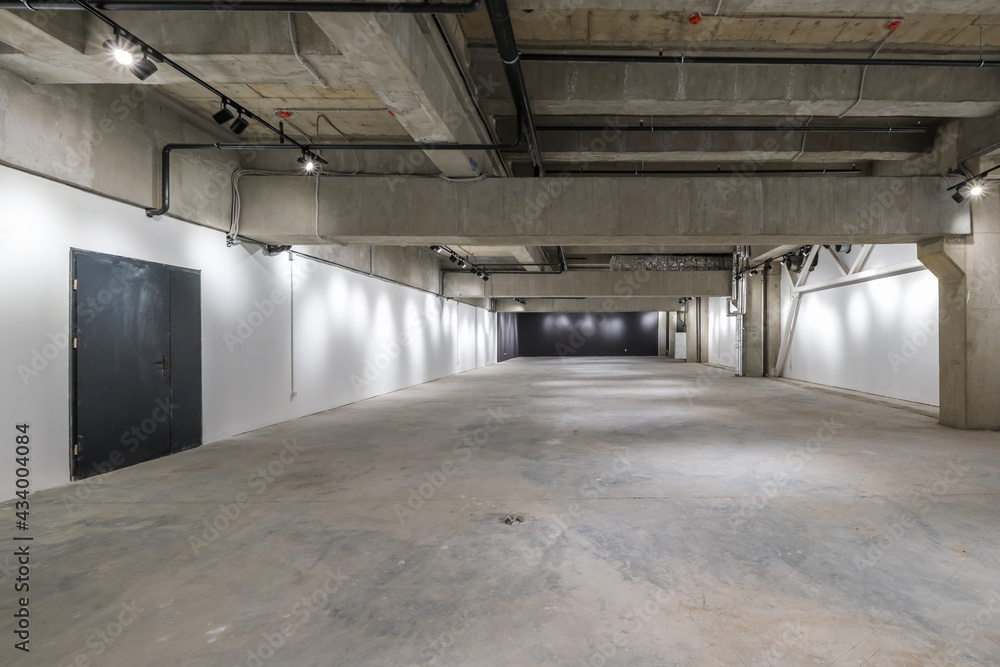 empty interior of large concrete room as warehouse or hangar with spotlights empty interior of large concrete room as warehouse or hangar with spotlights