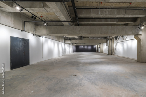 empty interior of large concrete room as warehouse or hangar with spotlights