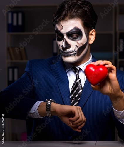Businessman with scary face mask working late in office © Elnur
