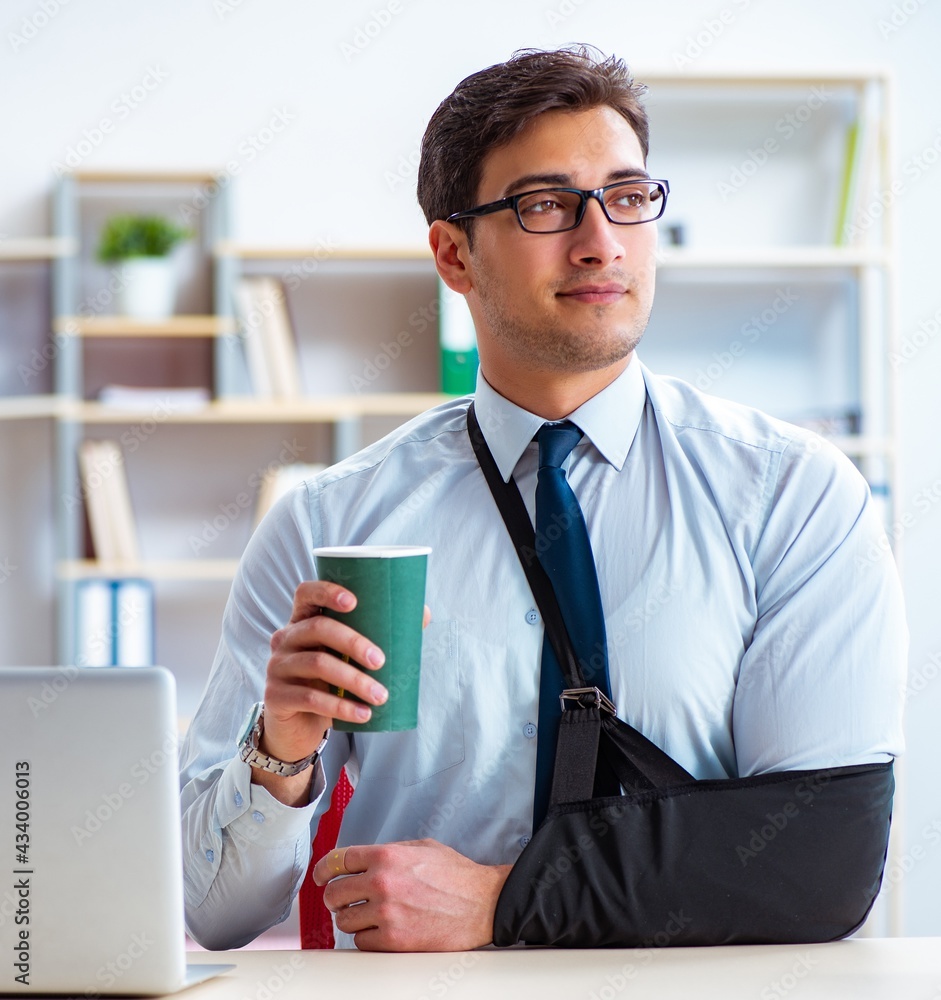 Businessman with broken arm working in office Businessman with broken arm working in office