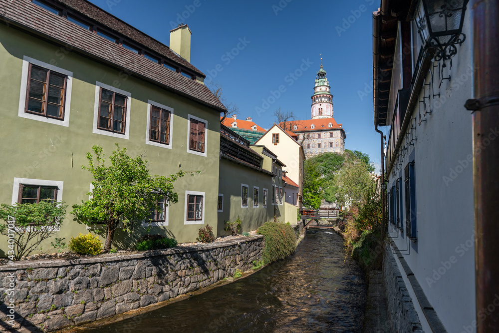 The Cesky Krumlov castle and tower standing guard above the town and a small river flowing through it.