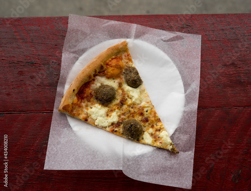 meatball and ricotta pizza on a plate on red table