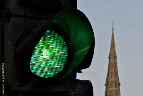 Closeup of green traffic light with out of focus church steeple in background, Camberwell, South London  photo