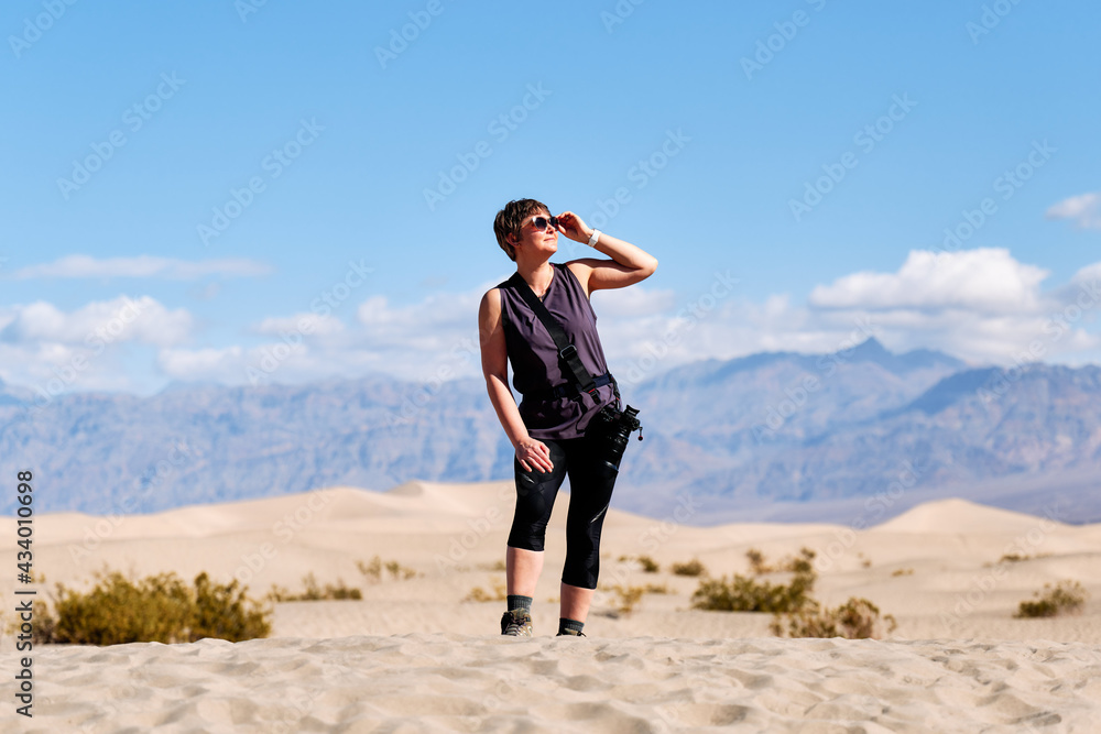 Obraz premium A family with a teenage girl is hiking in Mesquite Flat Sand Dunes, Death Valley National Park, California, USA during their road trip from Las Vegas to San Francisco in March 2021 amidst COVID-19