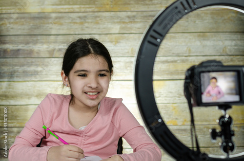 Latin Girl Recording Vlog Video Blog At Home With Camera,wooden background and ring light