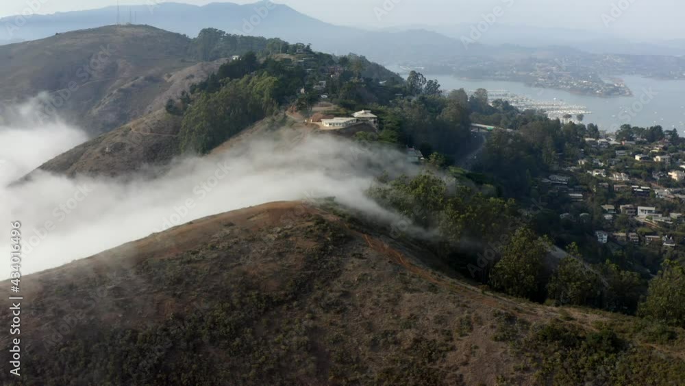 Fog pouring over the hills of Sausalito in the San Francisco Bay - California Fog pouring over the hills of Sausalito in the San Francisco Bay - California