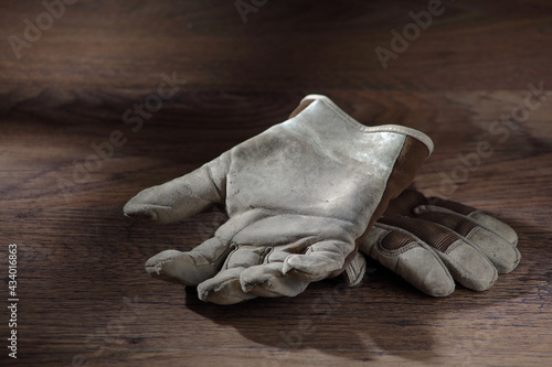 Work gloves on a wood surface with window light