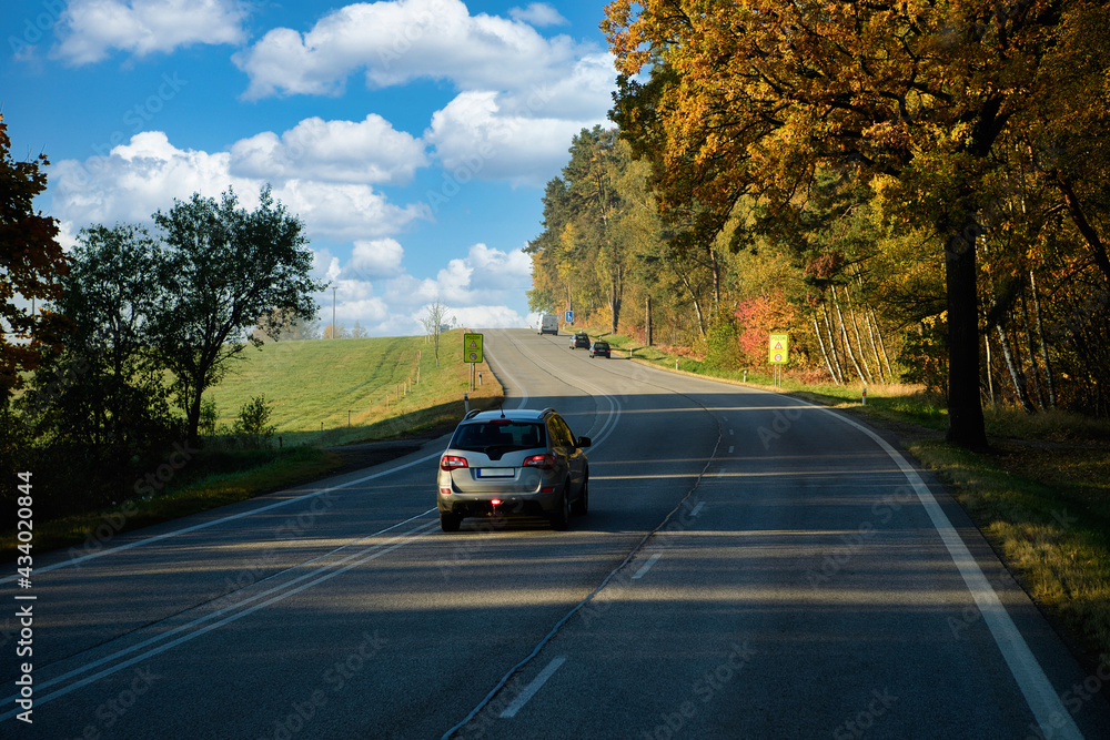 Travel with beautiful driving routes in Europe, asphalt roads and cars, with big trees changing color in autumn, rural views in the morning. The atmosphere is fresh and clear.