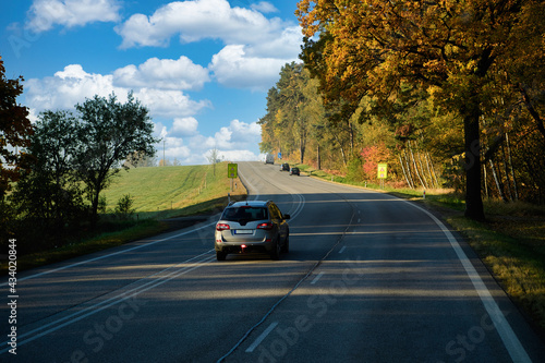 Obraz na płótnie Travel with beautiful driving routes in Europe, asphalt roads and cars, with big trees changing color in autumn, rural views in the morning. The atmosphere is fresh and clear. w salonie