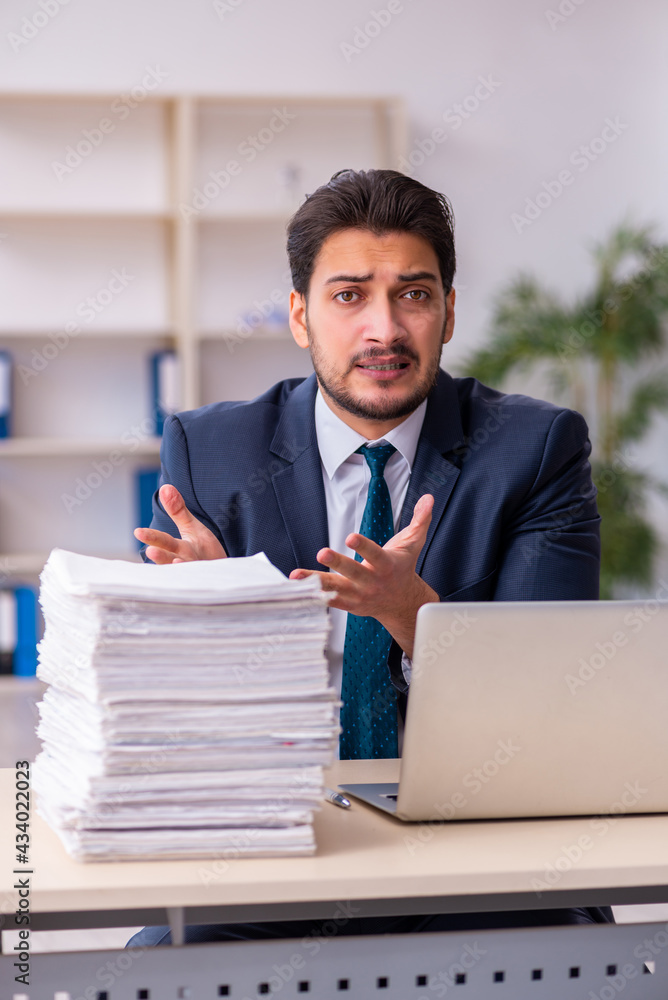 Young businessman employee and too much work in the office Young businessman employee and too much work in the office