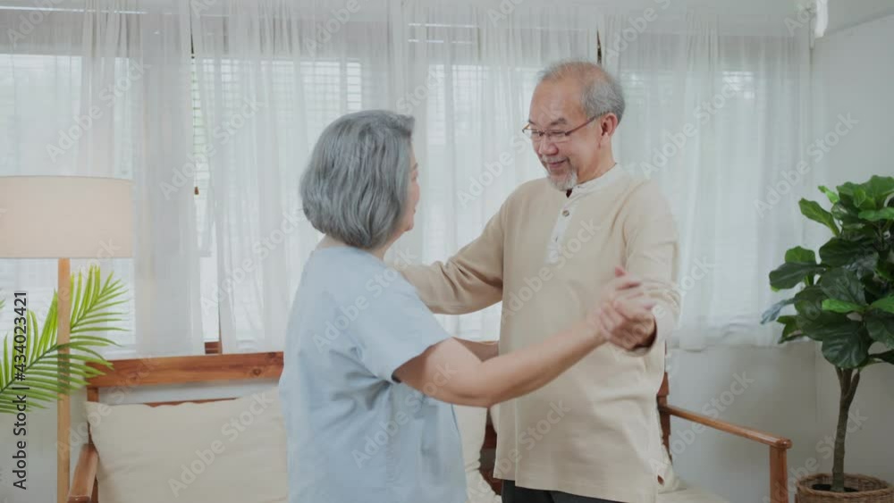 Asian senior couple enjoy dancing together in the living room at home. Asian senior couple enjoy dancing together in the living room at home.
