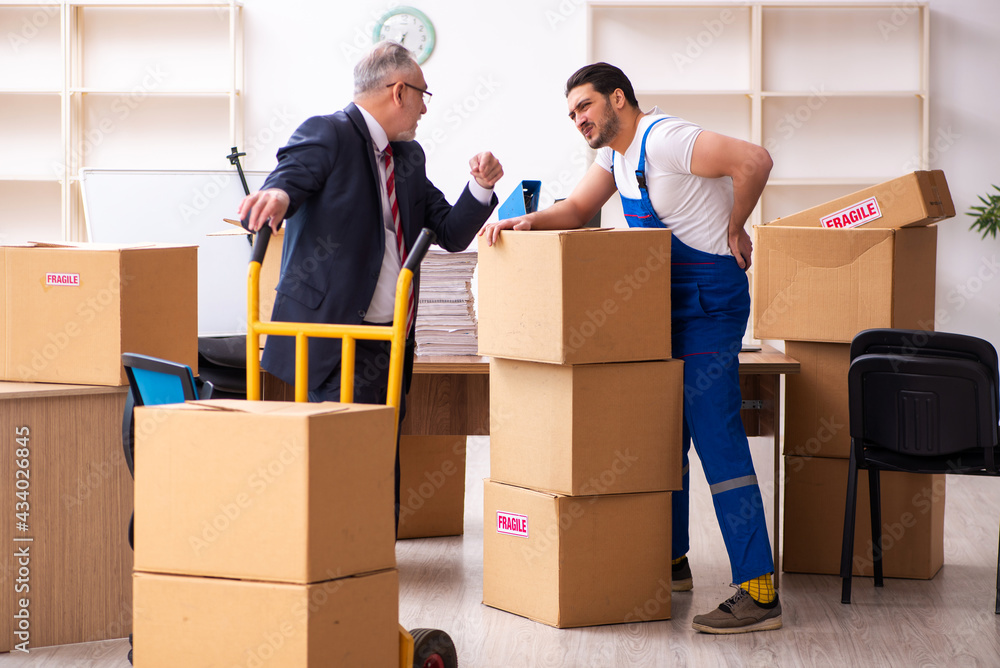 Old businessman and young contractor in relocation concept Old businessman and young contractor in relocation concept