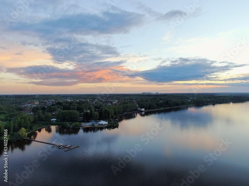 Aerial view sunset on the river. Colorful clouds are reflected in the water. Beautiful panorama of nature at sunset.