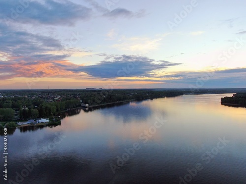 Aerial view sunset on the river. Colorful clouds are reflected in the water. Beautiful panorama of nature at sunset.