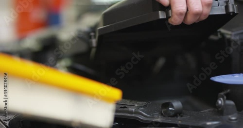 Changing car air filter by hands, mechanic regular maintenance, closeup view