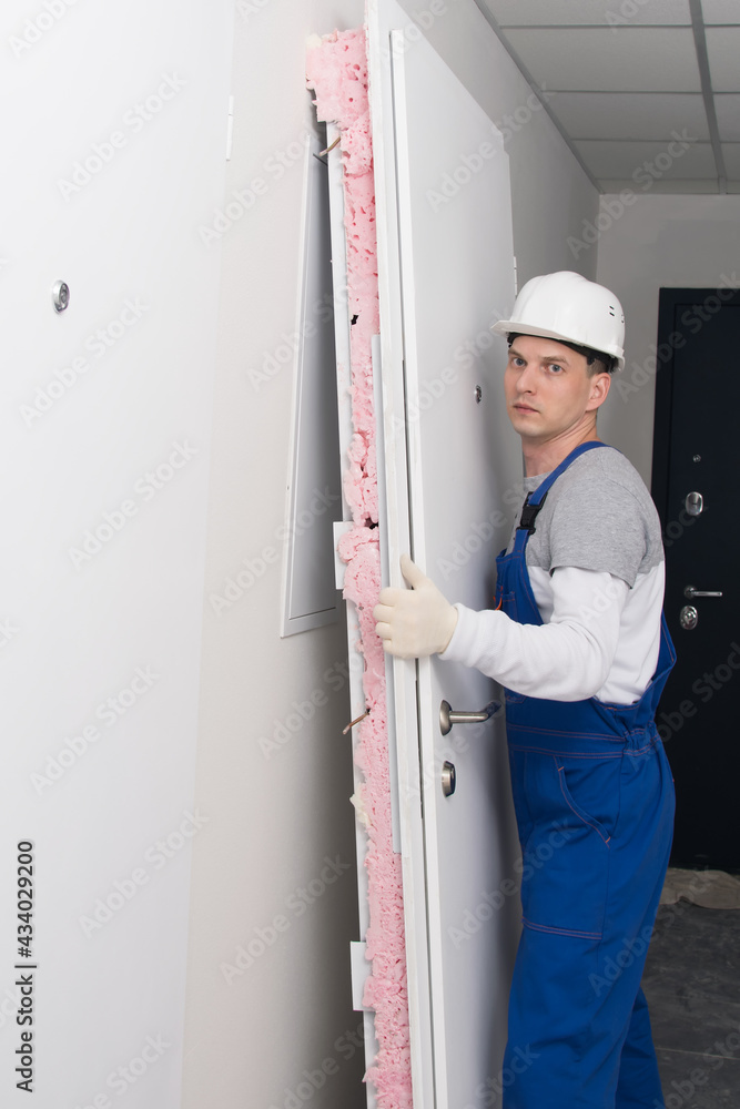 worker made dismantling of the old door, side view worker made dismantling of the old door, side view