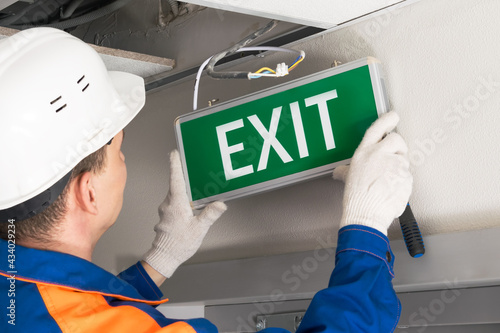 foreman completes installation of lighting signs emergency exit photo