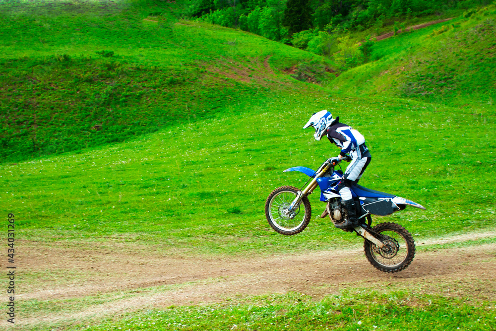 a professional motorcyclist rides off-road on one rear wheel a professional motorcyclist rides off-road on one rear wheel