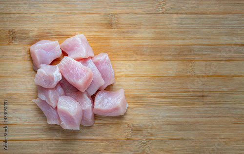 Close up fresh cube Pork Sirloin on wooden cutting board, top view image with blank space for copy and design.