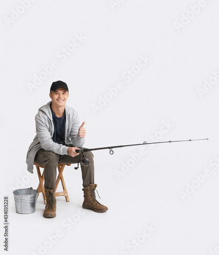 Teenage boy fishing on whit...