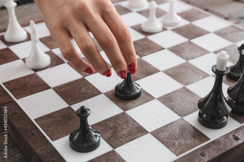 Woman playing chess on wooden background