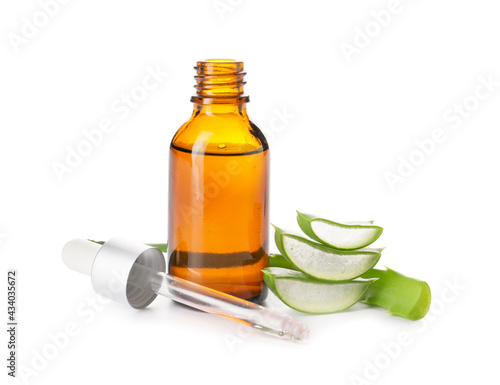 Bottle of essential oil and aloe pieces on white background