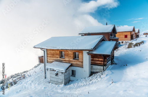 View of a forest covered with fresh snow and clouds near the Aletsch Arena. Switzerland in autumn photo