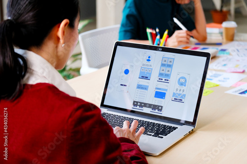 Website designer, Creative planning phone app development template layout framework wireframe design, User experience concept, Young asian woman UX designer working on smartphone application at office