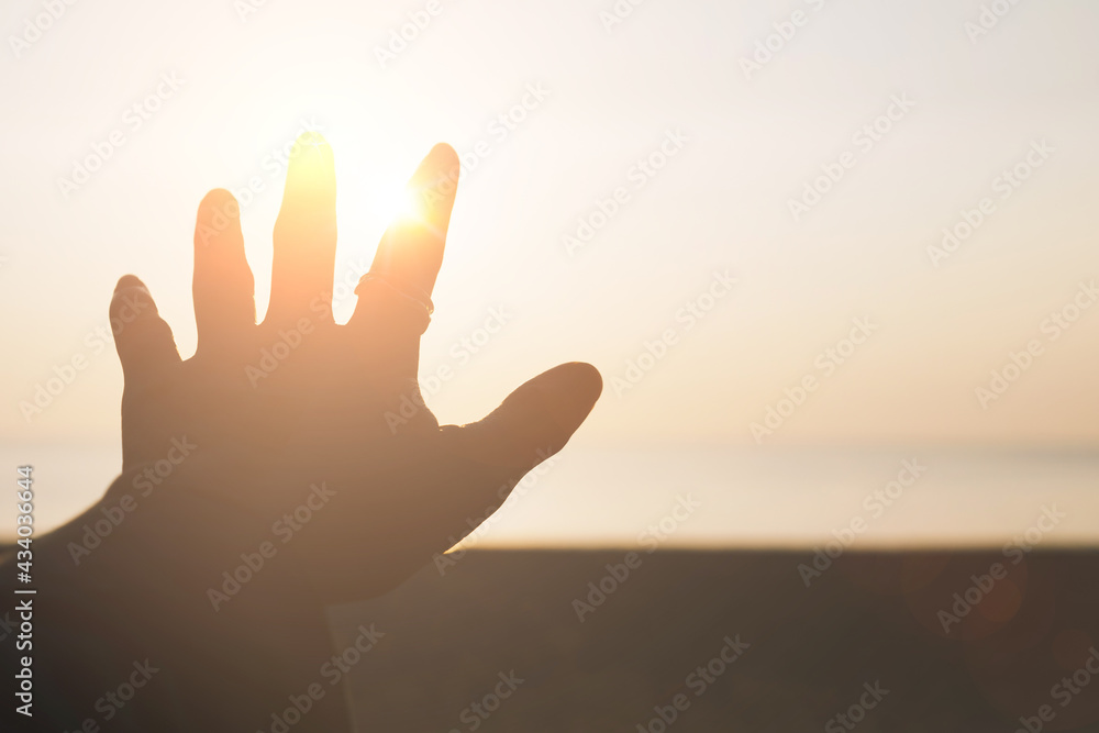 Hand reach out to sunset sky beach sand nature background relax and rest in vacation