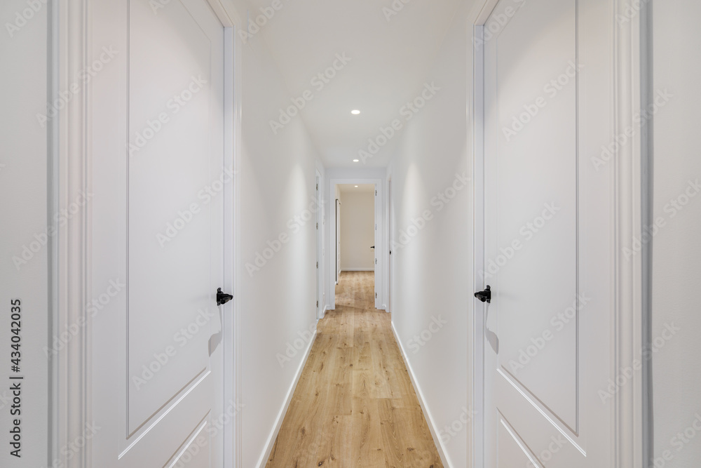 Ταπετσαρία Interior of long narrow hallway with closed doors, wooden floor and white walls in apartment designed in minimal style