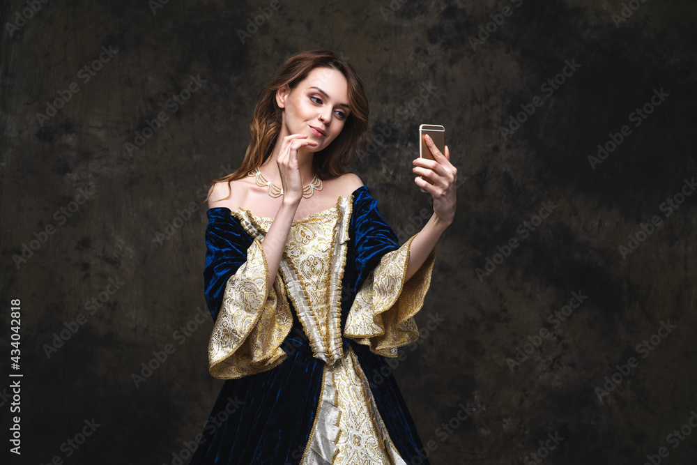 Beautiful woman in renaissance dress taking selfie on smartphone, old and new concept Beautiful woman in renaissance dress taking selfie on smartphone, old and new concept